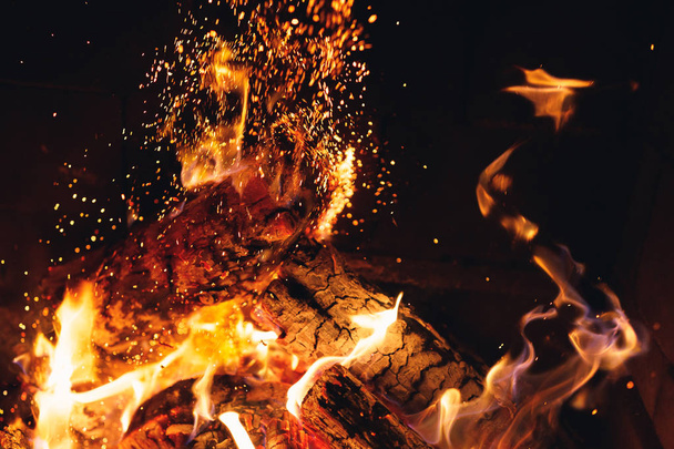 quema de troncos de fuego con chispas en la chimenea
 - Foto, Imagen