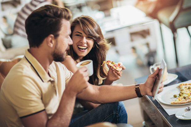 Tourné d'un jeune couple heureux mangeant de la pizza dans un restaurant
 - Photo, image