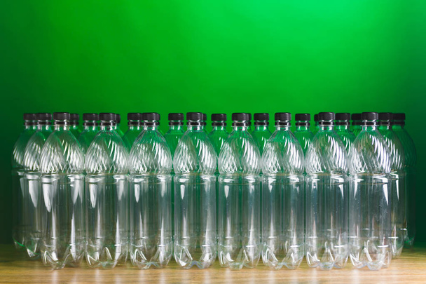 puste plastikowe butelki na zielonym tle - Zdjęcie, obraz