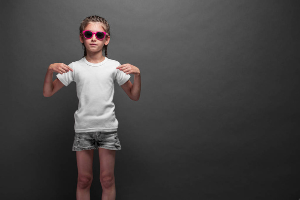 Kid girl wearing white t-shirt with space for your logo or design over gray background - Foto, afbeelding
