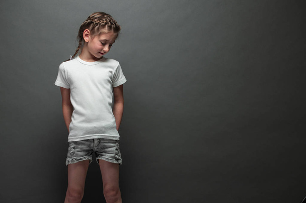 Kid girl wearing white t-shirt with space for your logo or design over gray background - Zdjęcie, obraz