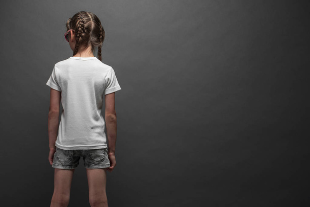 Kid girl wearing white t-shirt with space for your logo or design over gray background - Valokuva, kuva