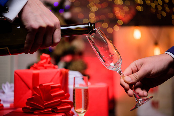 Last minute before new year. Drink champagne or sparkling wine. Celebrate holiday with champagne. Happy new year. Hands pouring champagne into elegant glass christmas decorations background - Φωτογραφία, εικόνα