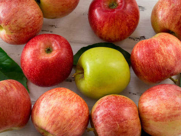 Hrubá červená a zelená jablka na bílém dřevěném stole, pohled shora. Plochý l - Fotografie, Obrázek