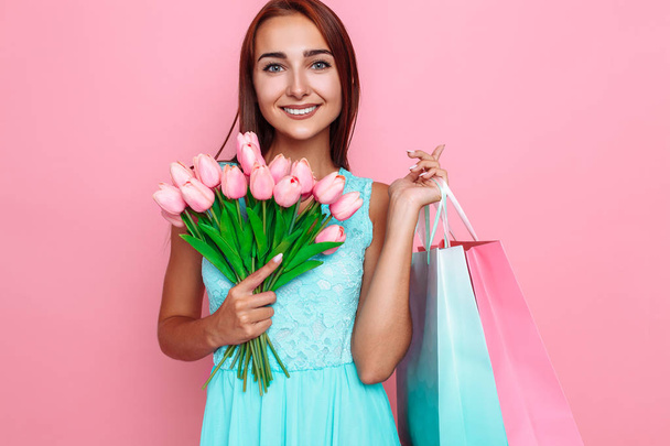 Cute girl in a bright dress holding a bouquet of flowers and sho - Fotografie, Obrázek
