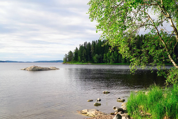 On the shore of lake Ladoga with a small stone island . - Zdjęcie, obraz