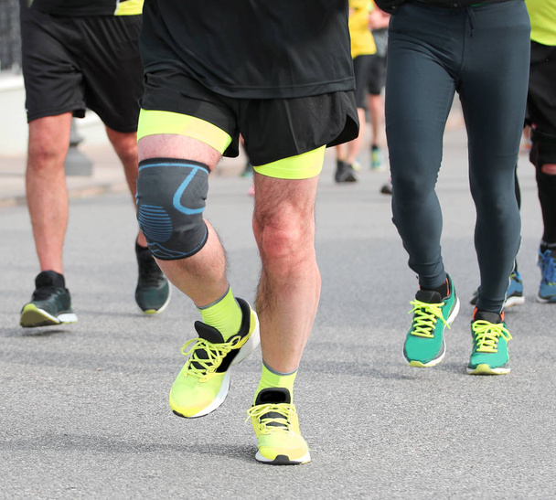 běžec během závodu na nohy s kapelou na kolenou - Fotografie, Obrázek