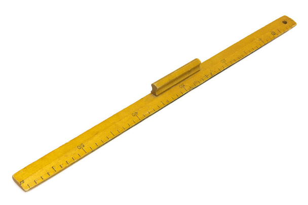 Régua de medição de madeira amarela em um fundo branco
 - Foto, Imagem