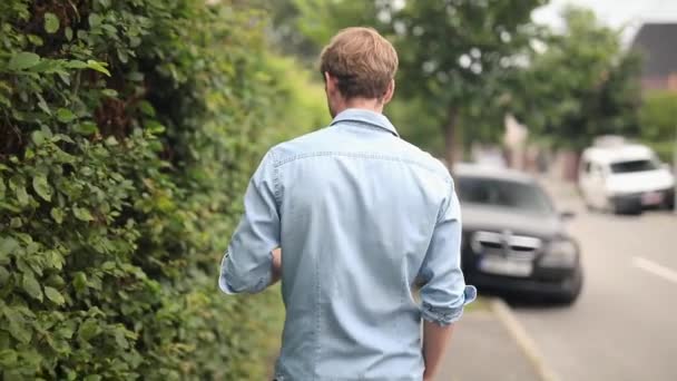 döner ve sokakta someon karşılamak için şaşırır yürüyen adamın arka görünümü - Video, Çekim