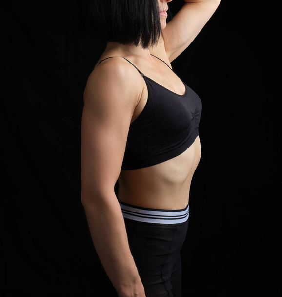 σώμα ενός κοριτσιού της αθλητικής εμφάνισης σε ένα μαύρο σουτιέν και γκέτα - Φωτογραφία, εικόνα