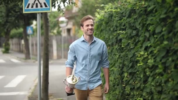 ενθουσιασμένος νέος περιστασιακή άντρας γιορτάζει την επιτυχία στο πεζοδρόμιο - Πλάνα, βίντεο