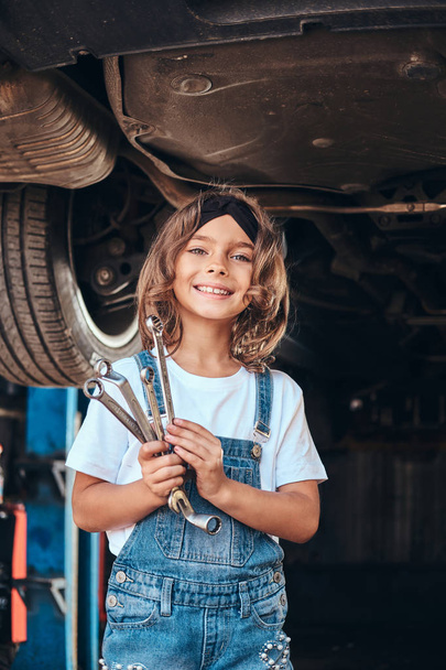 Portrait of cute little girl at auto service - Photo, Image