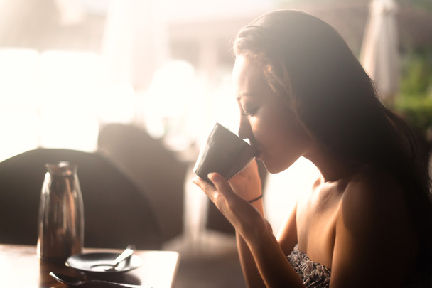 Привлекательная азиатка пьет из чашки
 - Фото, изображение