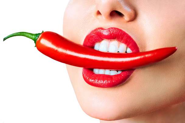 Beautiful woman teeth eating red hot chili pepper - Photo, Image