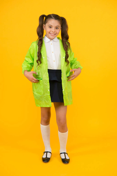 Enjoy fall weather with proper garments. Waterproof accessories make rainy fall day cheerful and pleasant. Schoolgirl in green cloak. Waterproof accessory. Kid girl happy wear waterproof cloak - Photo, Image