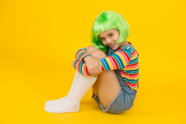 Kid girl with bright vibrant hairstyle. Artificial wig concept. Semi permanent color cream. Colored clip in hair extensions. Change color. Pigment dye hair. Freedom for expression. Fantasy hair trend - Foto, imagen