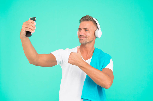 Selfie in gym concept. Healthy lifestyle. Gym aesthetics. Mature but still in good shape. Exercising in gym for better health. Man athlete taking selfie photo. Sportsman smartphone and headphones - Fotoğraf, Görsel
