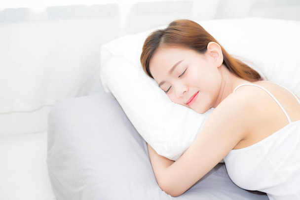 Hermosa mujer joven asiática durmiendo acostada en la cama con la cabeza en p
 - Foto, Imagen