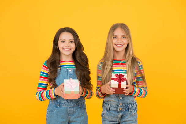 Being thankful for everything. Thankful for every gift of fate. Teaching kids be thankful. Children hold gift boxes yellow background. Kids delighted gifts. Girls celebrate holiday. Happy friends - Foto, afbeelding