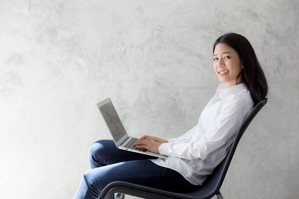 Mooie Aziatische jonge vrouw online werken op laptop zittend op  - Foto, afbeelding