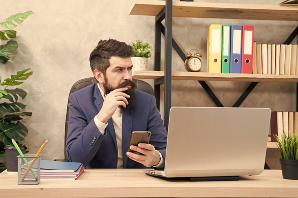 Male boss working with smartphone. Brutal businessman in office. Mature man with beard. bearded hipster use computer. Business message. Message to business partner. always in touch. what we gor here - 写真・画像