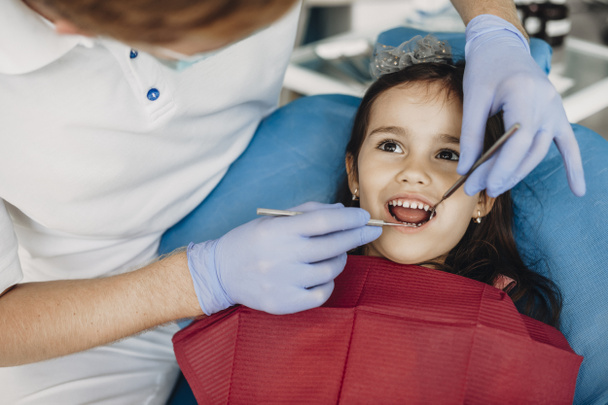 Close up of a cute little kid doing teeth surgery by a pediatric dentist. - Foto, Imagen
