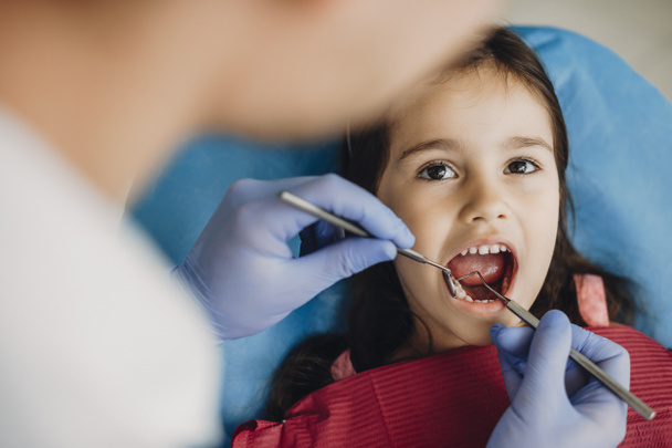 Gros plan d'un mignon enfant heureux faisant un examen dentaire dans une stomatologie pédiatrique
. - Photo, image