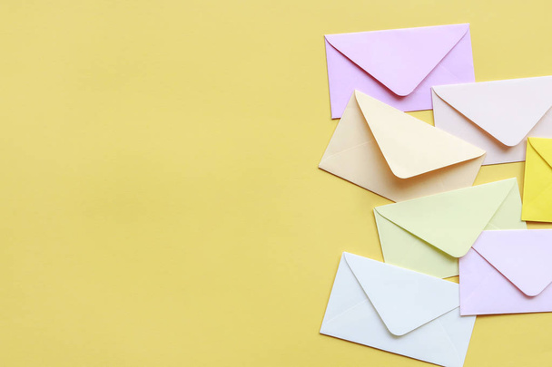 Colorful envelopes on yellow background - Foto, afbeelding