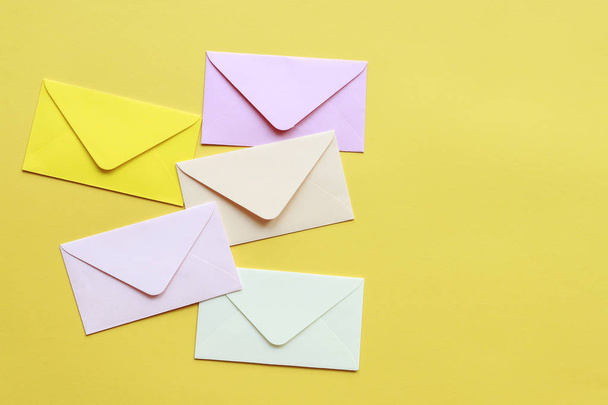 Colorful envelopes on yellow background - Фото, изображение