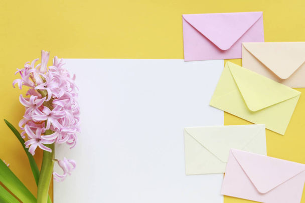 Colorful envelopes and hyacinth flowers on yellow background - Foto, imagen