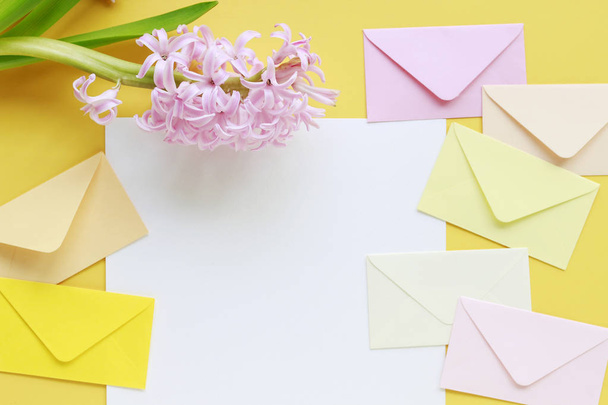 Colorful envelopes and hyacinth flowers on yellow background - Φωτογραφία, εικόνα