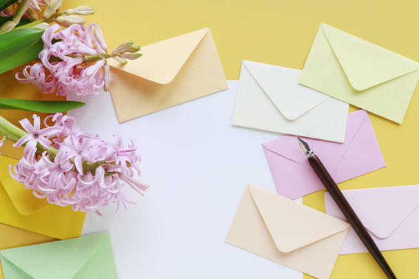 Colorful envelopes and hyacinth flowers on yellow background - Foto, Imagem