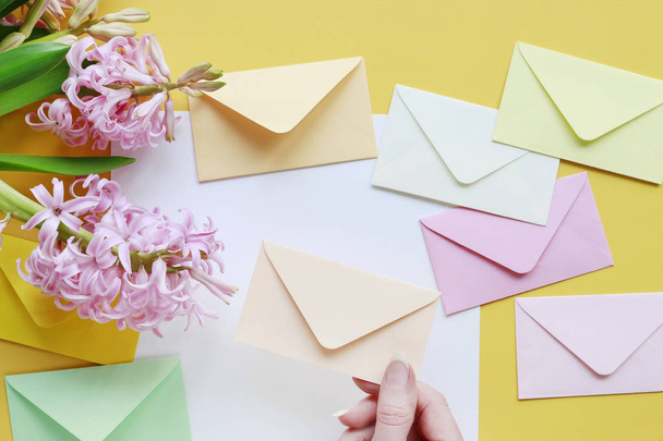 Colorful envelopes and hyacinth flowers on yellow background - Fotoğraf, Görsel