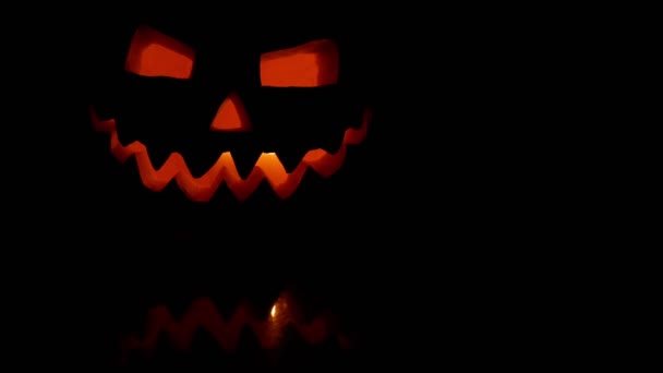 Schreckliche geschnitzte Halloween-Kürbisse in einem brennenden Feuer. Nachdenken. schwarzer Hintergrund. - Filmmaterial, Video