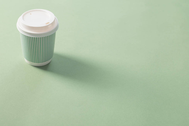 disposable paper cup with coffee on green background - Foto, Bild