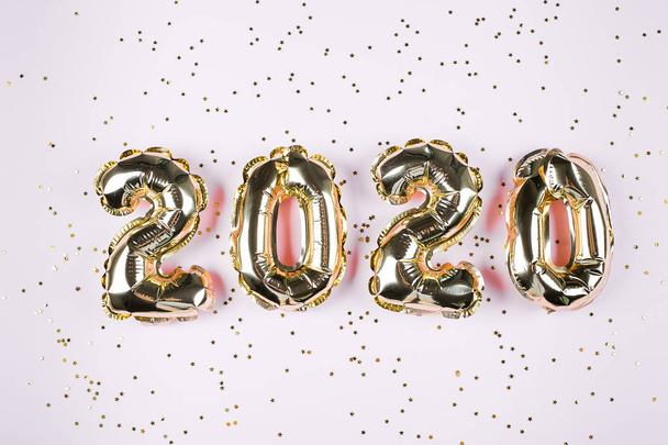 Nummers 2020 gemaakt van gouden ballonnen op roze achtergrond. Happy New Year concepten. - Foto, afbeelding