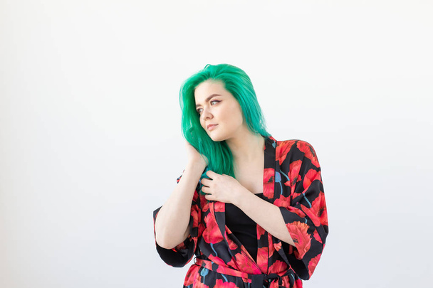 Fashion, style, hair coloring and people concept - young woman with green hair in colourful kimono over the white background - Foto, imagen