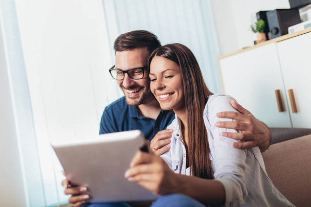 Mladí manželé sledují mediální obsah online v tabletu v li - Fotografie, Obrázek