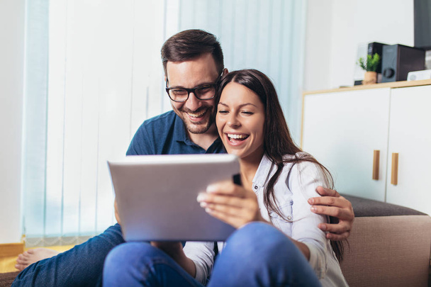 Mladí manželé sledují mediální obsah online v tabletu v li - Fotografie, Obrázek