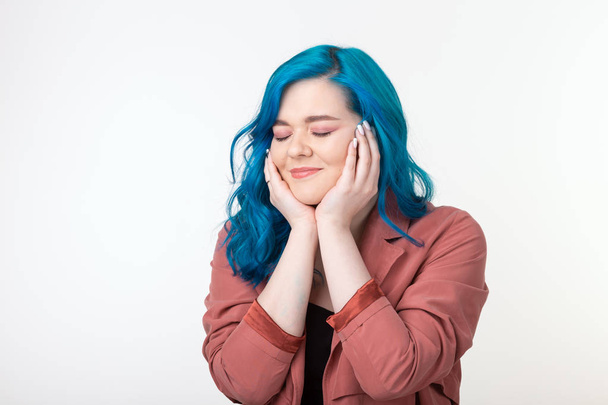 Menschen, Emotionen und Modekonzept - schönes Mädchen mit blauen Haaren und fröhlichem Gesicht auf weißem Hintergrund - Foto, Bild
