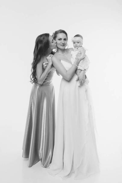 wedding fashion concept for women of all ages. A group of women in long evening dresses on a white background - Foto, Imagen