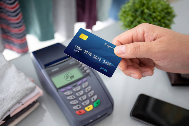 Man hand holding plastic card and pay pass online terminal - Foto, Imagem