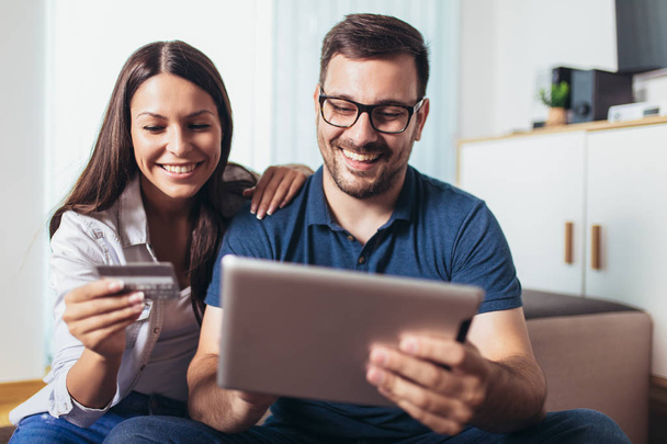 Sorrindo casal feliz com computador tablet pc e crédito ou banco
  - Foto, Imagem