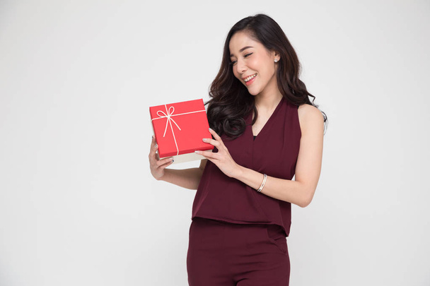 Feliz hermosa mujer asiática sonrisa con caja de regalo roja aislada sobre fondo blanco. Adolescentes en el amor
, - Foto, Imagen