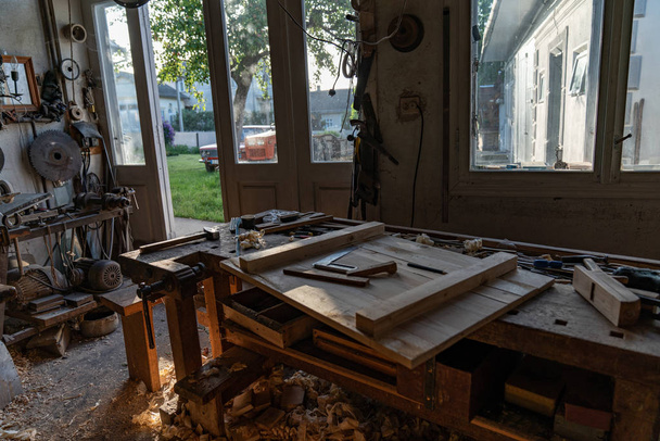 Foto de taller de madera bonita casa, un montón de herramientas en la mesa y colgar en la pared
 - Foto, Imagen