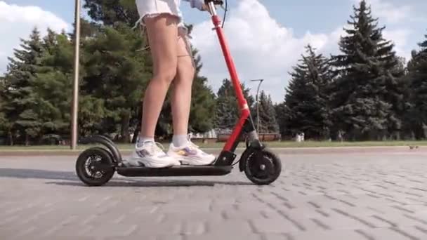 Facet z dziewczyną jazda na skuterze elektrycznym - Materiał filmowy, wideo
