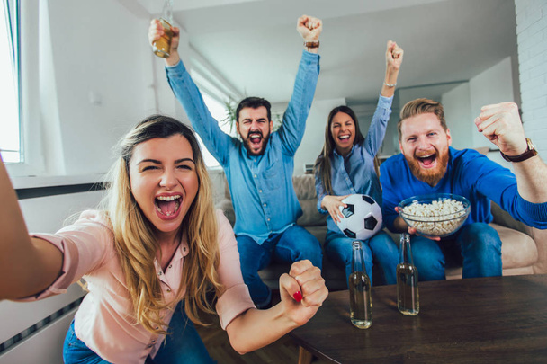 Счастливые друзья или футбольные фанаты смотрят футбол по телевизору и празднуют
 - Фото, изображение