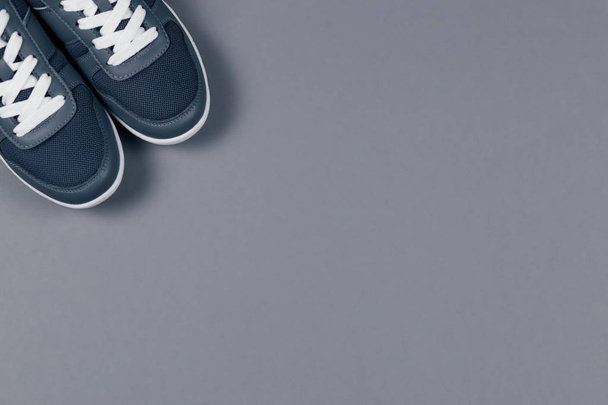 Sneakers grigie sullo sfondo grigio. Concetto per uno stile di vita sano e allenamento quotidiano
.  - Foto, immagini