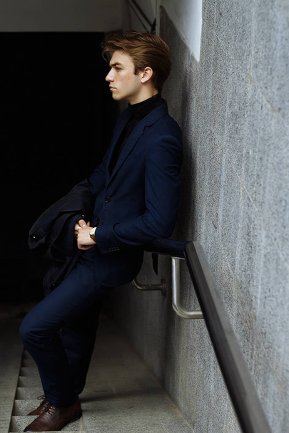 portrait of an attractive young man in a blue suit in the city - Photo, image