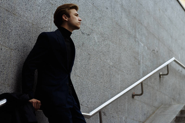 portrait of an attractive young man in a blue suit in the city - 写真・画像